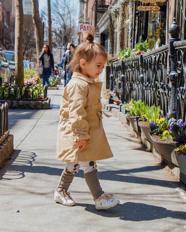 Secondhand Mode für Mädchen Kleines Mädchen trägt einen beigen Secondhand Trenchcoat