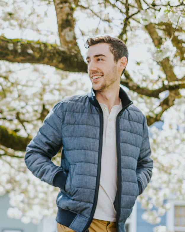 Secondhand Herren Mode Ein Mann trägt im Frühling eine blaue Secondhand Daunenjacke