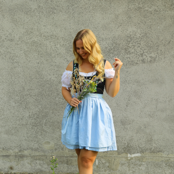Frau trägt blau schwarzes Dirndl