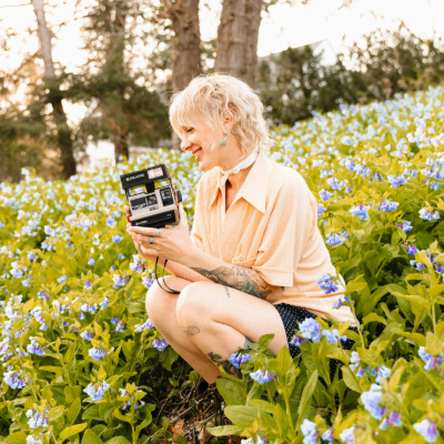 Frau sitzt in einer Blumenwiese