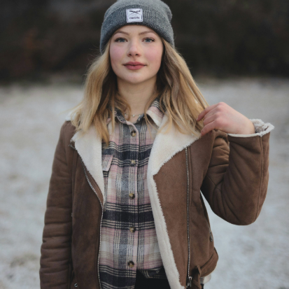 Secondhand Jacken Frau trägt ein Secondhand Outfit und eine Shearling Jacke