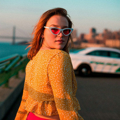 Frau trägt Sonnenbrille und eine gelbe secondhand Bluse